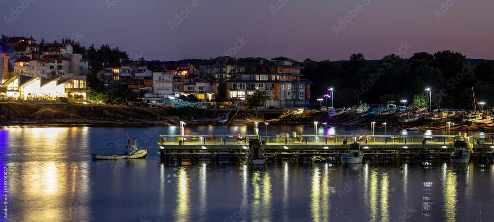 Seascape. View of the pier. Night scene with reflections. Ahtopol resort, Southern Black Sea coast.  Bulgaria.