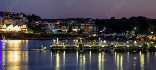 Seascape. View of the pier. Night scene with reflections. Ahtopol resort, Southern Black Sea coast. Bulgaria.