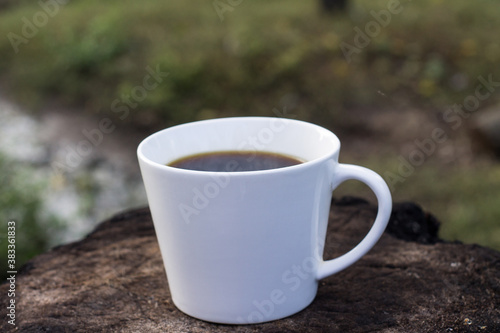 white coffee cup on wood stand with blurred background