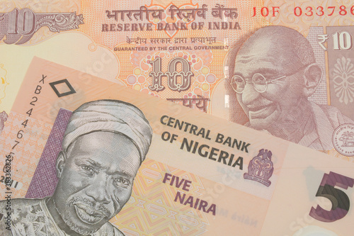 A macro image of a orange ten rupee bill from India paired up with a orange, plastic five naira note from Nigeria.  Shot close up in macro.