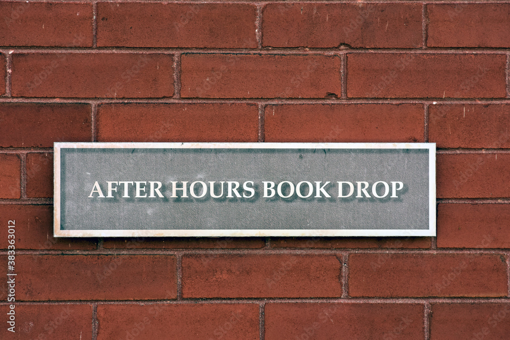After hours book drop sign at a public library.
