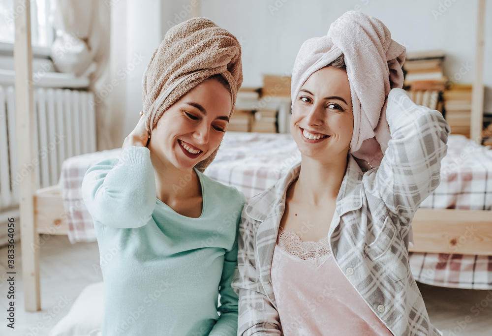 Obraz premium Two girls make homemade face and hair beauty masks. Cucumbers for the freshness of the skin around the eyes. Women take care of youthful skin