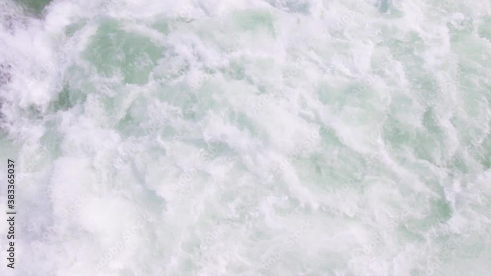 Whitewater rapids at first before panning up to towering mountains and forest Whitewater rapids at first before panning up to towering mountains and forest