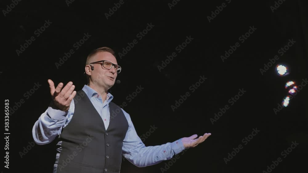 an inspiring speaker from the stage tells how to become successful and productive