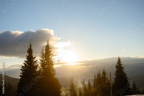 Ski piste and chair lift with snow covered trees on sunny day. Combloux ski area, French alps