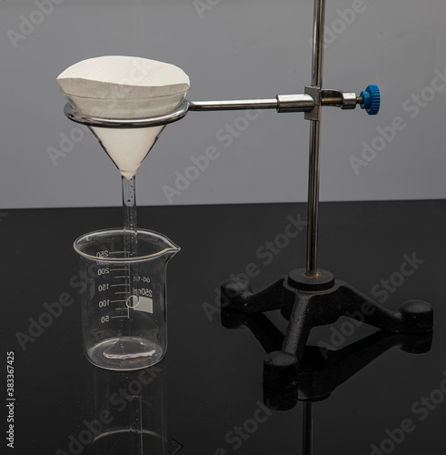 Filter paper in laboratory. Scientists are chemical filtration by filtering through filter paper in a glass funnel, Close up. photo