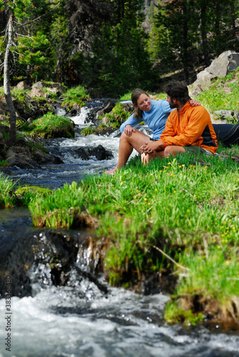 Hiker couple relaxing by a cold mountain stream