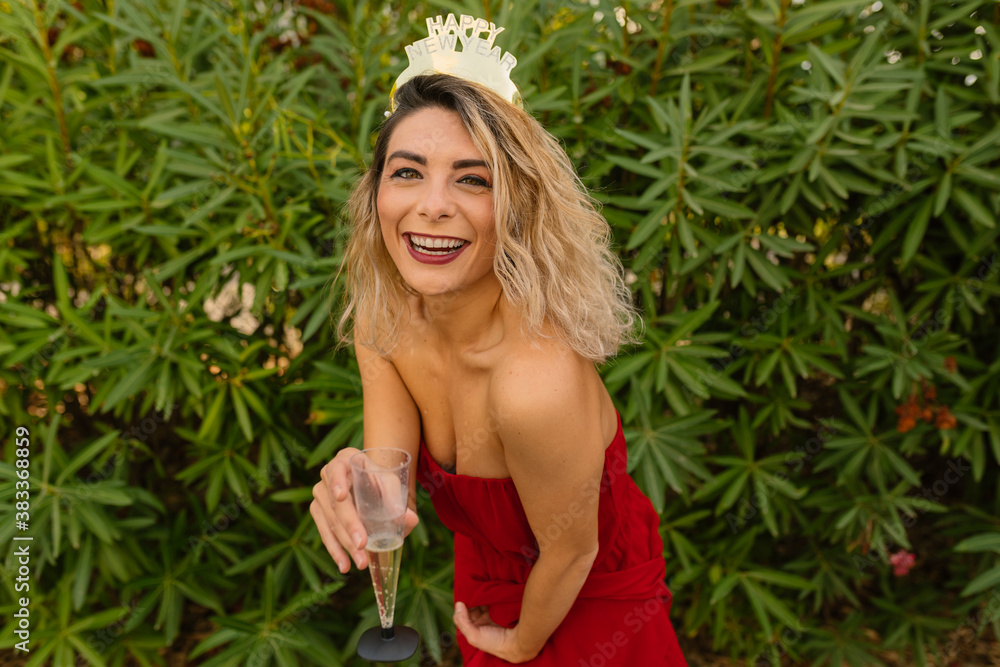 blond woman offering glass of champagne at party over green background. Christmas and New year holiday. glass in focus blond woman offering glass of champagne at party over green background. Christmas and New year holiday. glass in focus