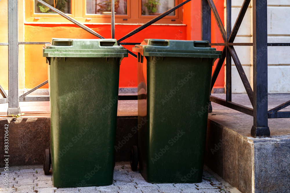 Green trash cans in front of the house. Green trash cans in front of the house.