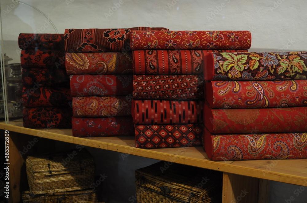 Many rolls of vintage red printed fabrics