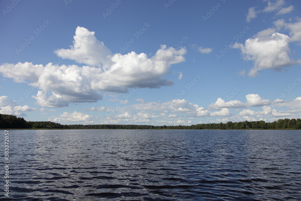 Beautiful Medveditsa river with coast green trees and grass stripe on Horizon on blue sky with white clouds and calm water background at summer day, scenery Russian natural landscape view