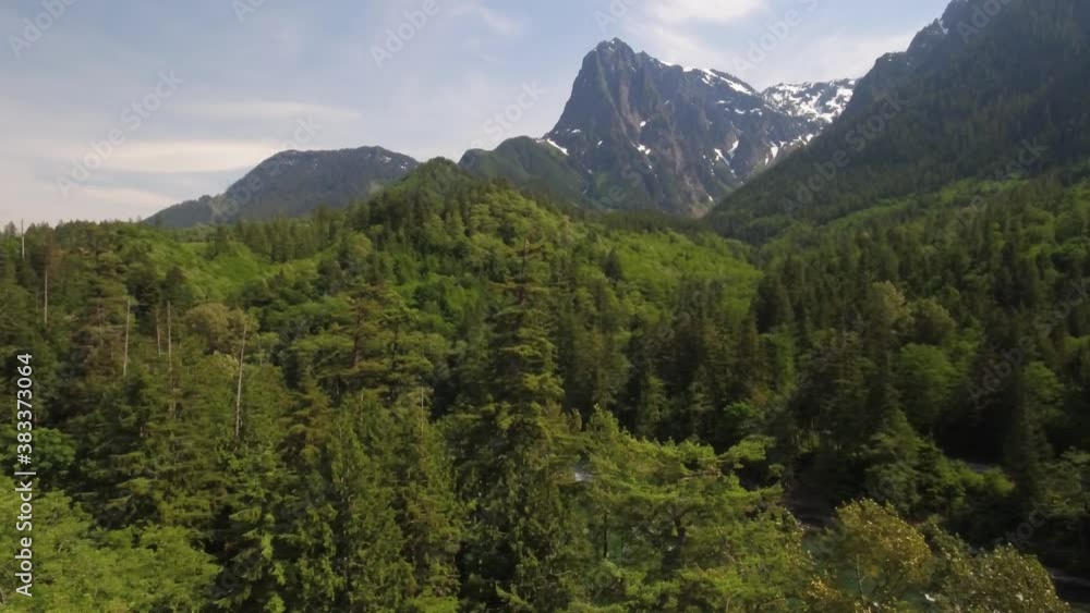 Side aerial reveal of cascading river and mountains with green forest all around. Index Washington State Side aerial reveal of cascading river and mountains with green forest all around. Index Washington State