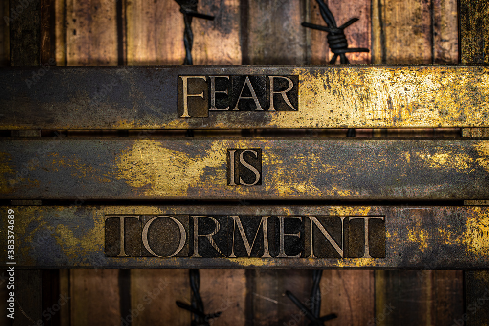 Fear is Torment text message on textured grunge copper and vintage gold background with barbed wire