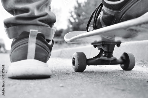 Close-up fragment of skateboard and feet, monochrome retro stylized photo