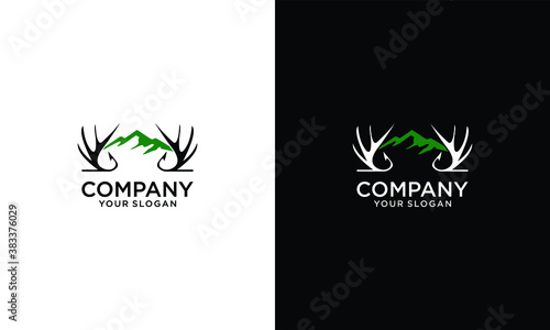 Hand drawn travel badge with deer antlers and mountains textured vector illustration and "Be wild and free" inspirational lettering.