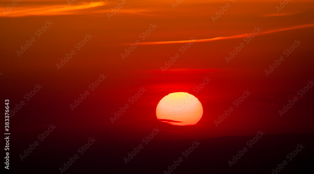 Obraz premium bug sun at sunset with clouds in the dark