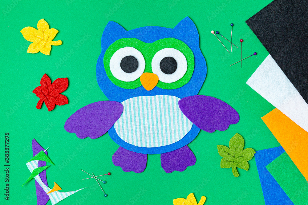 Naklejka premium Craft, applique of an owl from multi-colored felt. Creative classes with children. Sewing soft toys, hobby.