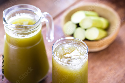 The cane juice or garapa is the liquid extracted from the sugar cane in the milling process. Sweetened, organic drink with pieces of cane in the background