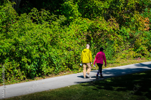 Man and woman waling on a path next to a forest