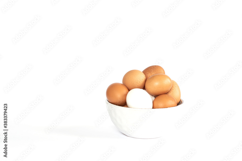 Eggs lay on white background. Food ingredient. Close-up view of raw chicken eggs in bowl. Eggs lay on white background. Food ingredient. Close-up view of raw chicken eggs in bowl.