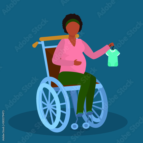 a pregnant black young woman in a wheelchair holds baby sliders on a hanger in her hand