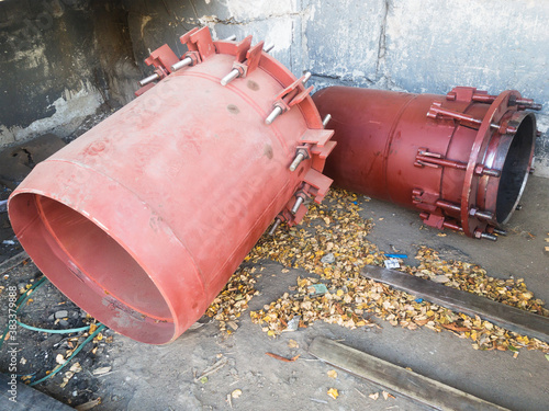 Red gland expansion joints for heating main on concrete floor. Heat and power concept.