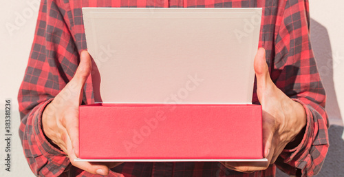 A person's hand holds an open gift box
