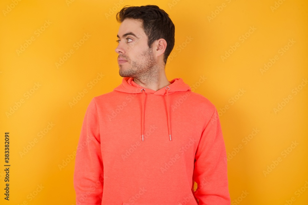 Close up side profile photo Handsome man with sweatshirt over isolated yellow background ready to have a walk. Close up side profile photo Handsome man with sweatshirt over isolated yellow background ready to have a walk.