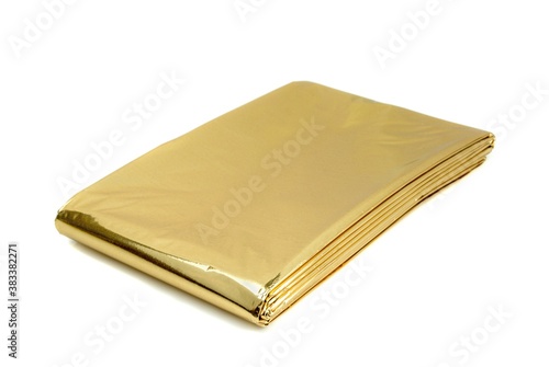 A golden aluminium foil emergency first aid kit heat sheet on a white background