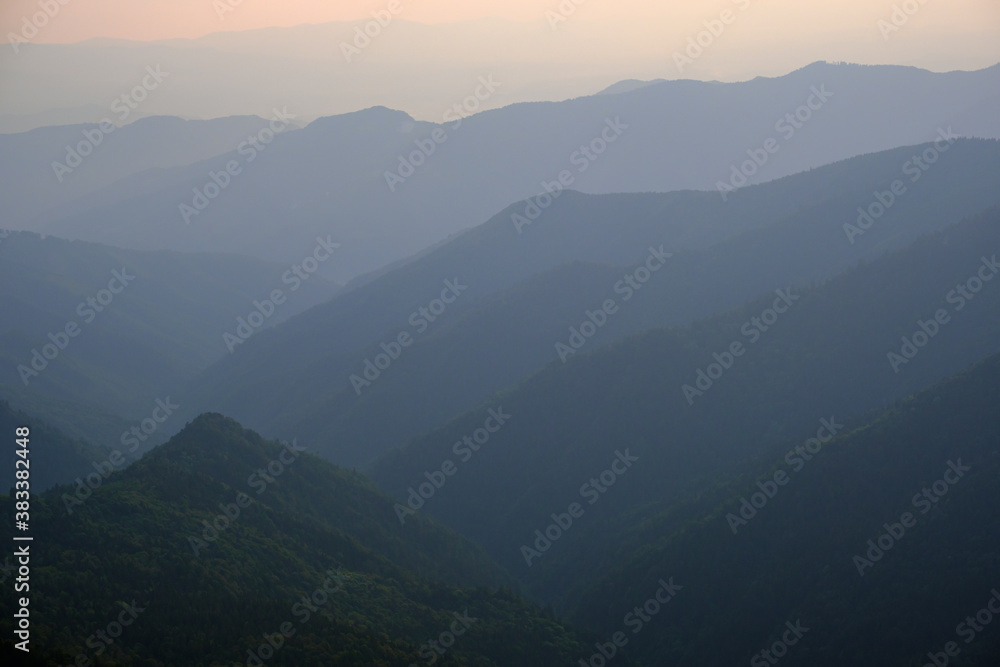 Summer misty evening mountain tops silhouettes. Marmaros, Carpathian, Ukraine.