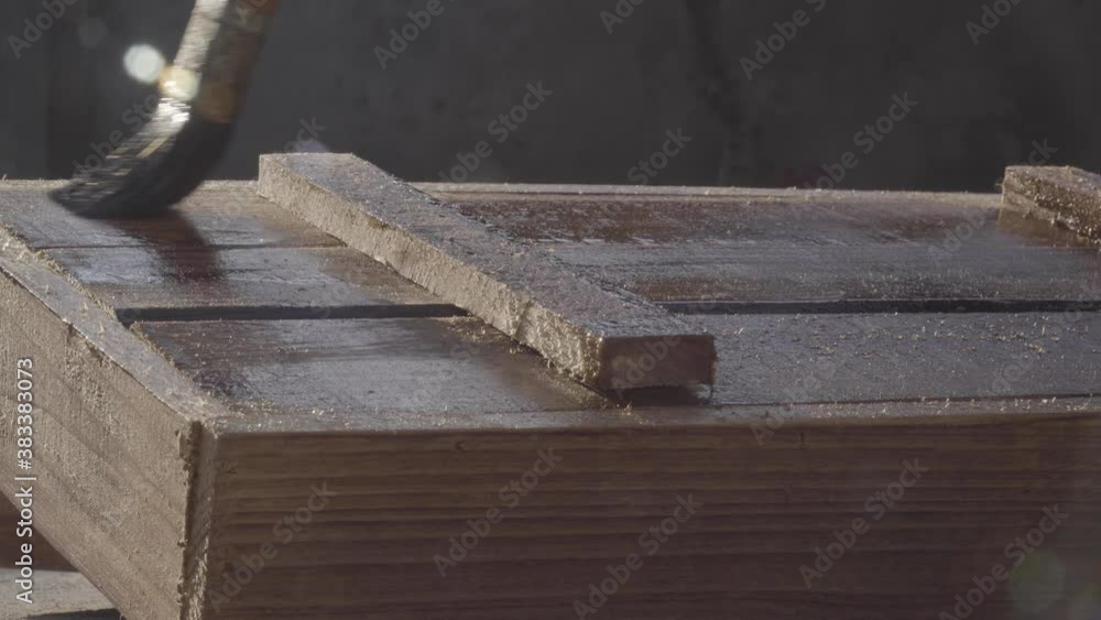 Spreading linseed oil on wood with brush Spreading linseed oil on wood with brush