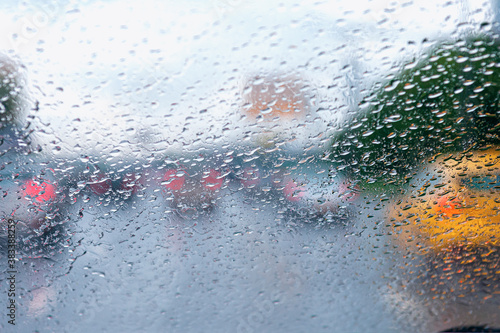 Heavy rain, raindrops on the windshield, blurred cloudy background from a car window. Raindrops on a windshield in rainy weather.