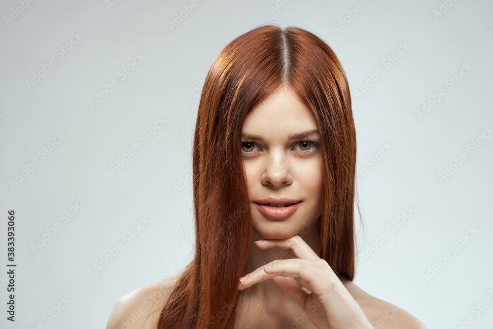 pretty redhead woman holding her hair with hands grooming naked shoulders light background pretty redhead woman holding her hair with hands grooming naked shoulders light background
