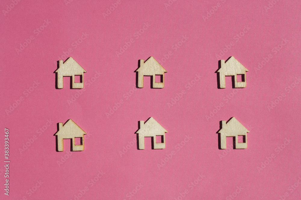 mini wooden houses on pink background mini wooden houses on pink background