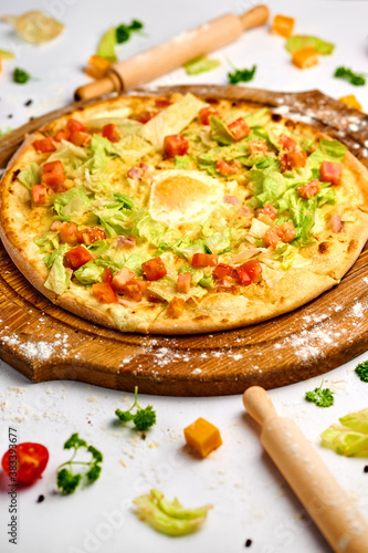 Pizza with bacon meat, egg yolk and green salad