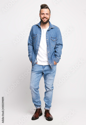 Young man in denim suit. Handsome man in denim jacket and jeans on a white background. Photo for advertising men's jeans and jackets. Concept for advertising © Дмитрий Скорина