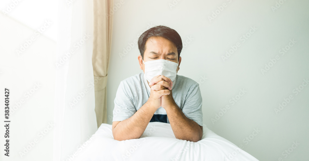 Man wear face mask lockdown quarantine at home during coronavirus covid19. Praying with faith worship online.Hands folded in prayer for health and business.Thanksgiving, Healing Religion.Christian. Man wear face mask lockdown quarantine at home during coronavirus covid19. Praying with faith worship online.Hands folded in prayer for health and business.Thanksgiving, Healing Religion.Christian.