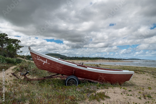 Boat at the beach. Red boat at the beach under a cloudy sky near Piriapolis, Uruguay. photo