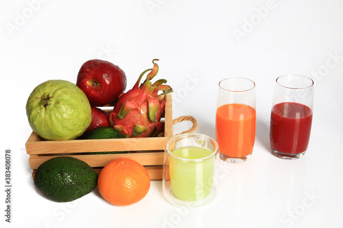 Variouse fresh fruit in wooden basket and juice in glasses