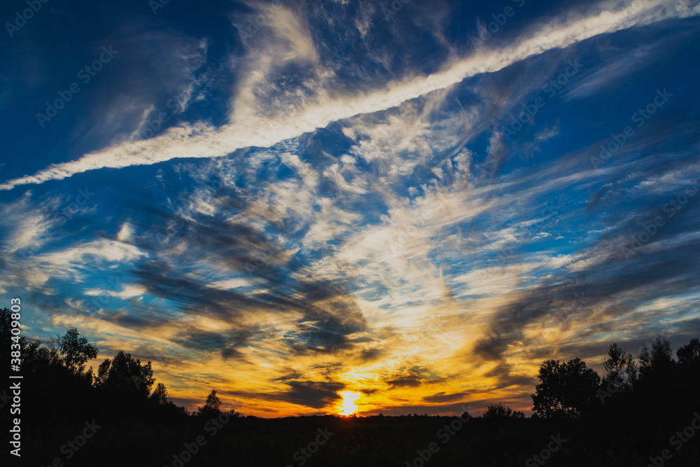Fototapeta premium Colorful sunset with light and dark clouds.
