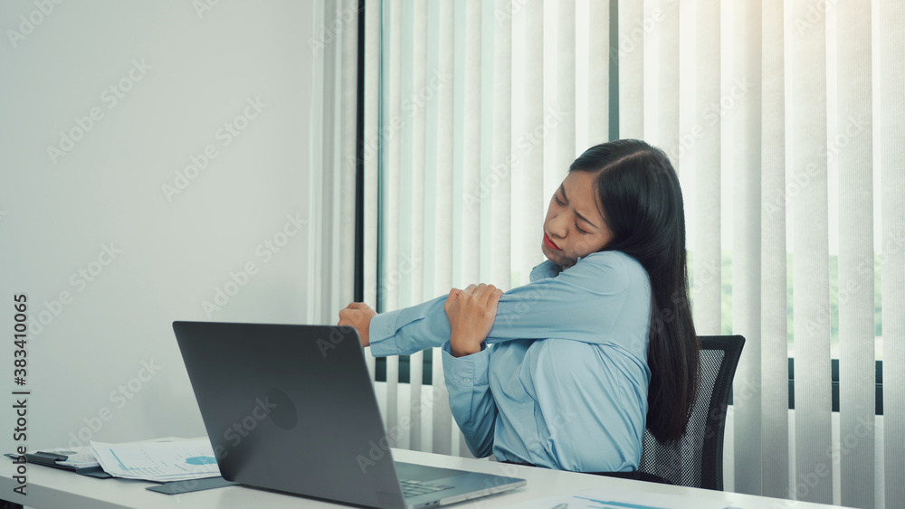 Fototapeta premium Young asian women stretch their muscles while sitting at the office to relax from the stress.