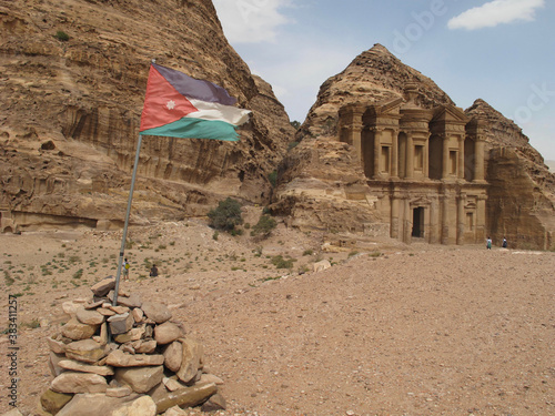 The flag of Jordan framing a view of the Ad-deir, or Monastery, in the ancient Nabatean city of Petra