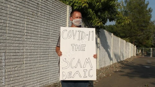 Anti COVID Protester with Mesh Mask - Scam Demic Tracking Shot photo