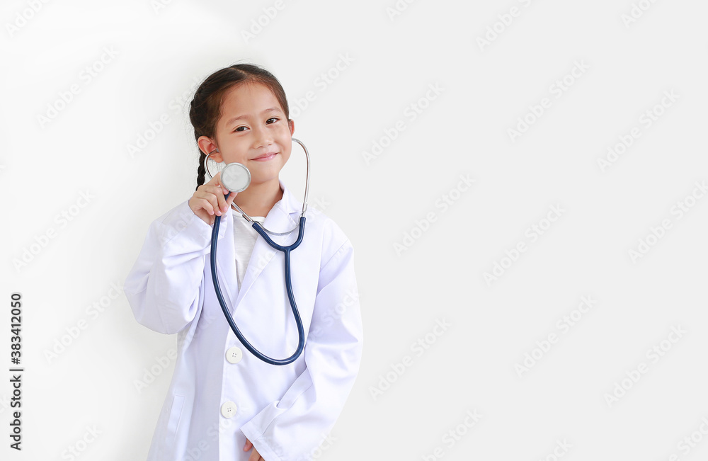 Portrait of smiling asian little child girl with stethoscope while wearing doctor's uniform isolated on white background with copy space Portrait of smiling asian little child girl with stethoscope while wearing doctor's uniform isolated on white background with copy space