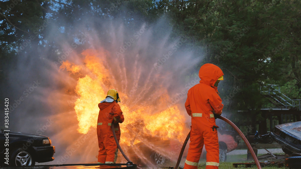 Firefighter fighting with flame using fire hose chemical water foam spray engine. Fireman wear hard hat, body safe suit uniform for protection. Rescue training in fire fighting extinguisher