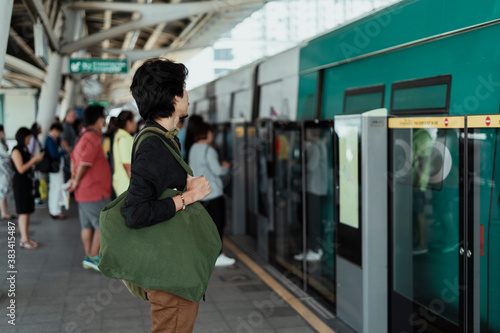 Canvas Print Asian man waiting for a train on platform.