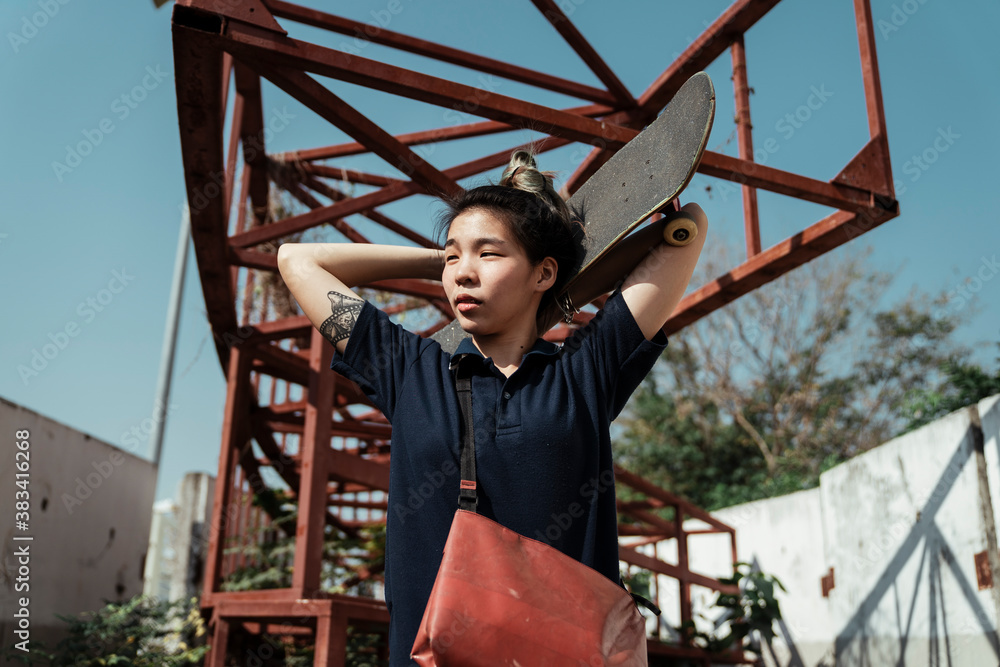 Skateboard player woman carry board over head. Skateboard player woman carry board over head.
