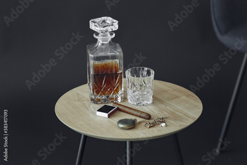 Glass of whiskey with cigar on table. Close up photo of alcohol and cigar.