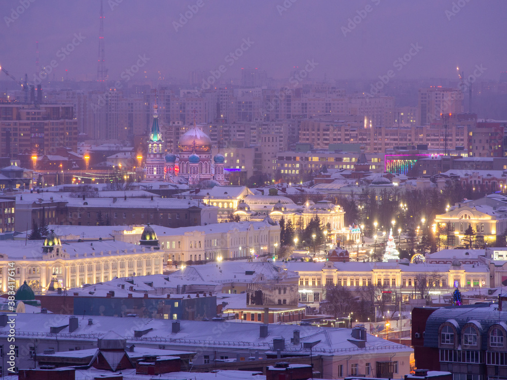 Obraz premium The historical center of Omsk from a height: Lenin Street, the Drama Theater and the Assumption Cathedral in the evening in the winter with the lights on.