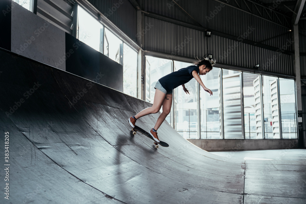 Fototapeta premium Skateboard player woman rinding board on rusty curve.